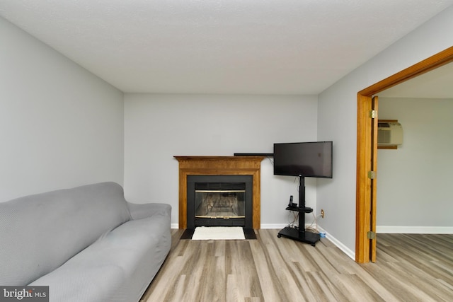 8225 Triple Crown Rd, Bowie, MD 20715 - living room featuring wood finished floors, a wall mounted air conditioner, and a fireplace with flush hearth