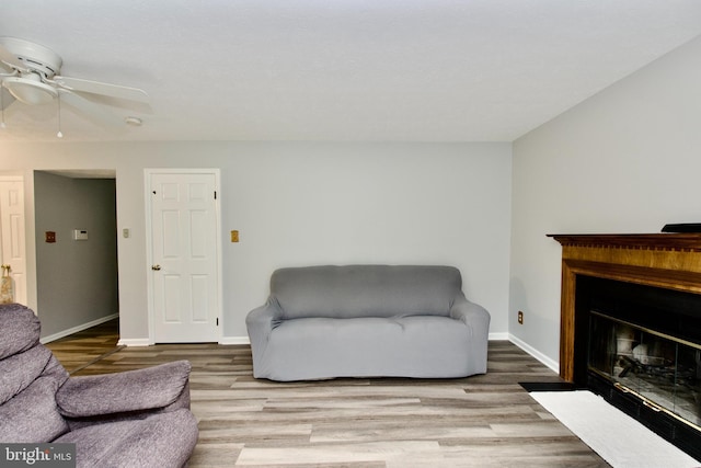 8225 Triple Crown Rd, Bowie, MD 20715 - living area with wood finished floors, a fireplace with flush hearth, and a ceiling fan