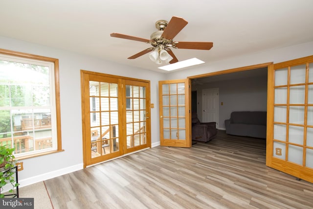 8225 Triple Crown Rd, Bowie, MD 20715 - unfurnished room with french doors, wood finished floors, ceiling fan, and a skylight