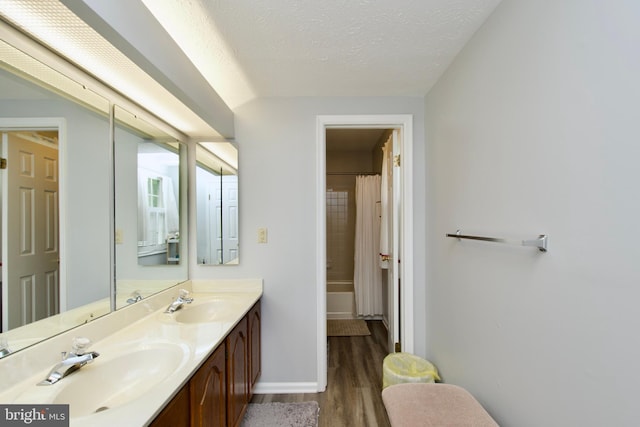 8225 Triple Crown Rd, Bowie, MD 20715 - full bath with wood finished floors, double vanity, a textured ceiling, and shower / bath combo with shower curtain