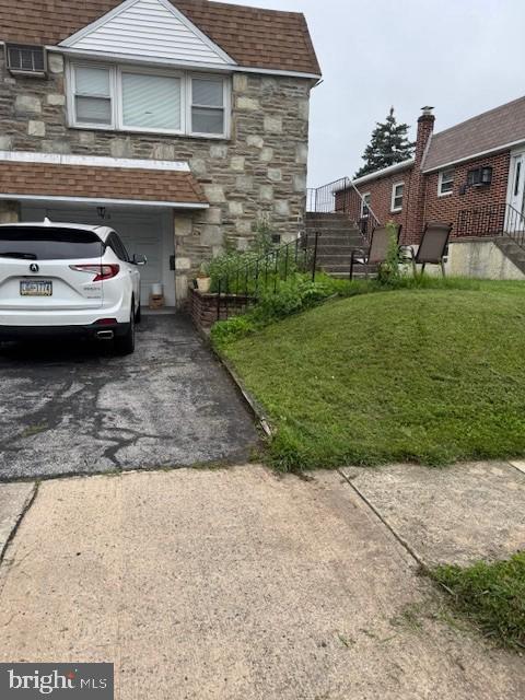 418 Jefferson St, Lansdale, PA 19446 - view of property exterior with stone siding, driveway, a yard, and roof with shingles