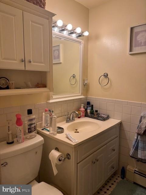 418 Jefferson St, Lansdale, PA 19446 - half bath with a baseboard heating unit, tile walls, vanity, and a wainscoted wall