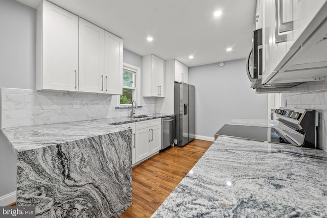 8405 58th Ave, College Park, MD 20740 - kitchen featuring stainless steel appliances, light stone countertops, white cabinets, decorative backsplash, and recessed lighting