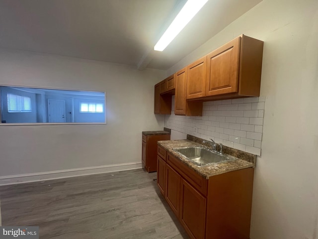 2001 N 52nd St, Philadelphia, PA 19131 - kitchen with decorative backsplash, wood finished floors, brown cabinetry, and dark countertops