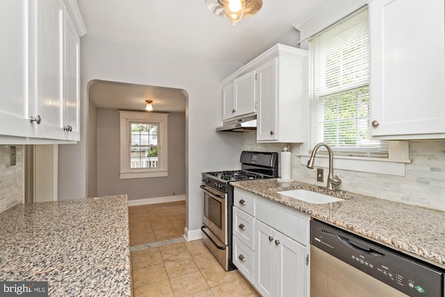 5100 Eugene Ave, Baltimore, MD 21206 - kitchen with stainless steel appliances, under cabinet range hood, white cabinets, tasteful backsplash, and light stone counters