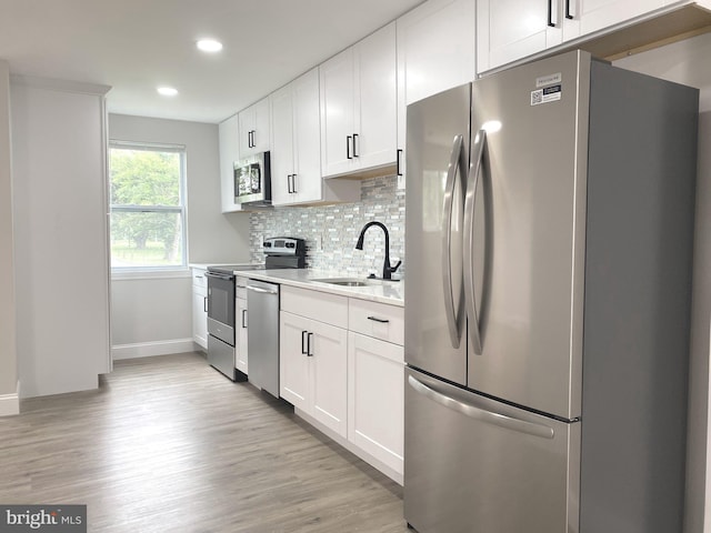 1319 Rainer Rd, Brookhaven, PA 19015 - kitchen featuring appliances with stainless steel finishes, light countertops, decorative backsplash, light wood-style flooring, and recessed lighting