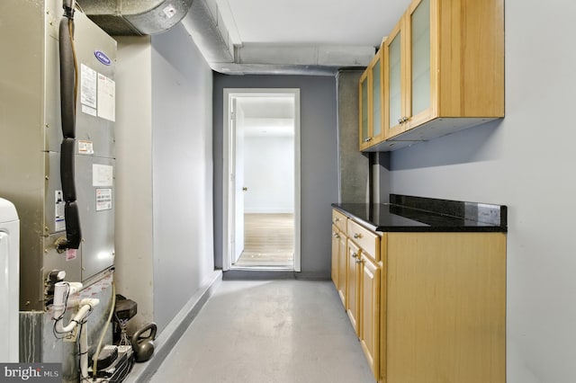 13727 Mahoney Dr, Woodbridge, VA 22193 - kitchen featuring concrete flooring, light brown cabinetry, glass insert cabinets, heating unit, and dark countertops