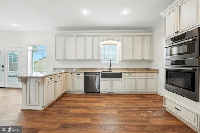 9936 Bell Wood Farm Ln, Nokesville, VA 20181 - kitchen featuring stainless steel appliances, crown molding, a peninsula, wood finished floors, and light stone countertops