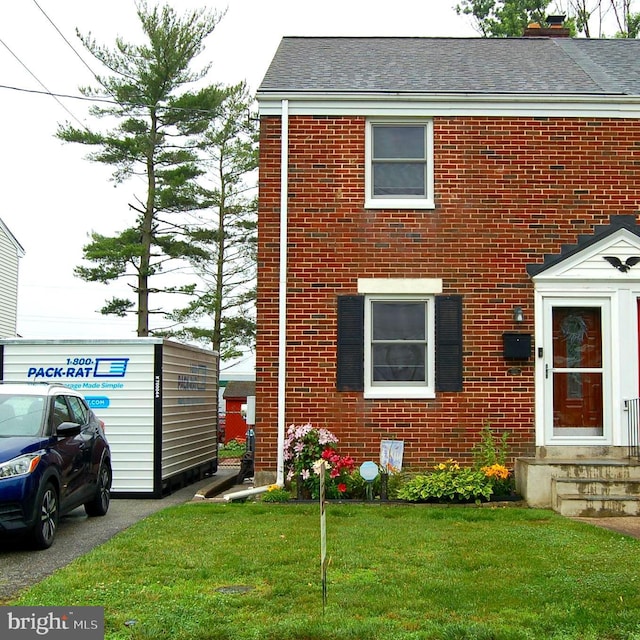 1400 Windsor Ave, Wilmington, DE 19804 - view of front of home featuring brick siding, a front yard, a chimney, and a shingled roof