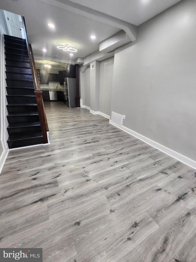 708 N Madeira St, Baltimore, MD 21205 - finished below grade area with wood finished floors, stairs, freestanding refrigerator, and recessed lighting