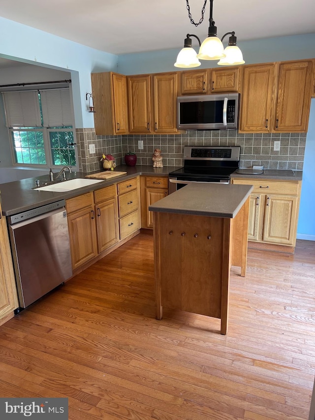674 Honeysuckle Way, Pennsburg, PA 18073 - kitchen with stainless steel appliances, decorative backsplash, a center island, light wood-type flooring, and decorative light fixtures
