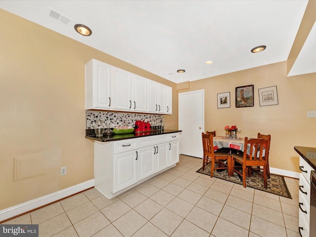18040 Singing Pine Cir, Montgomery Village, MD 20886 - kitchen with dark countertops, tasteful backsplash, white cabinets, light tile patterned floors, and recessed lighting