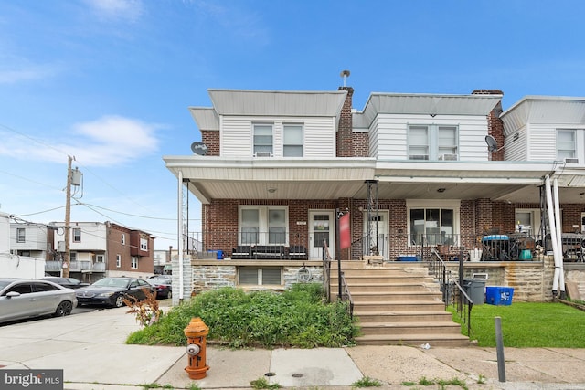 4029 Creston St, Philadelphia, PA 19135 - view of property featuring a porch, brick siding, and stairway