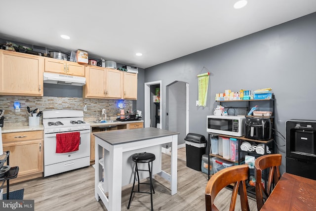 4029 Creston St, Philadelphia, PA 19135 - kitchen featuring white appliances, under cabinet range hood, light brown cabinets, decorative backsplash, and light wood-type flooring