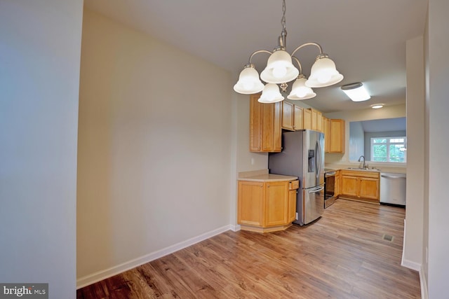2 N Cummings Dr, Middletown, DE 19709 - kitchen featuring stainless steel appliances, a chandelier, light countertops, light wood-type flooring, and pendant lighting