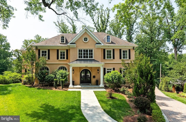 3801 52nd St NW, Washington, DC 20016 - colonial house with stucco siding, a front yard, a standing seam roof, and french doors