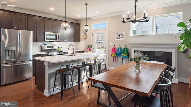 103 Norma Aly, Annapolis, MD 21403 - kitchen with appliances with stainless steel finishes, dark brown cabinets, a kitchen island with sink, light countertops, and a kitchen bar