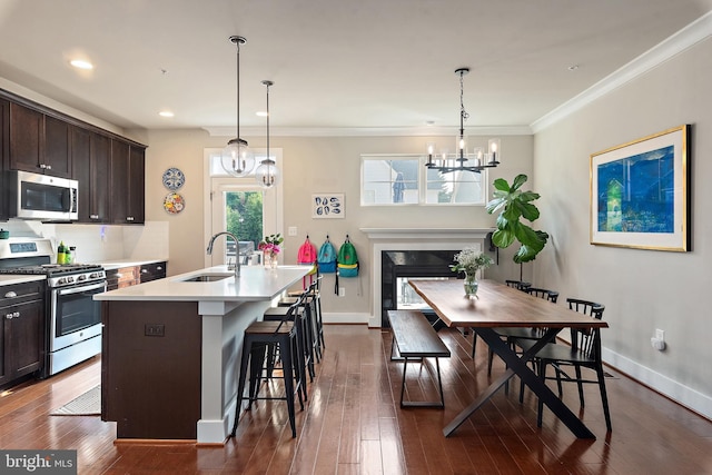 103 Norma Aly, Annapolis, MD 21403 - kitchen featuring appliances with stainless steel finishes, a chandelier, dark brown cabinets, a kitchen island with sink, and light countertops