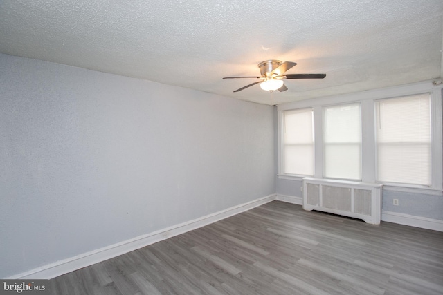 7152 N 20th St, Philadelphia, PA 19138 - empty room with radiator heating unit, a ceiling fan, wood finished floors, and a textured ceiling