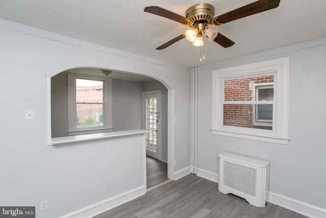 7152 N 20th St, Philadelphia, PA 19138 - spare room with arched walkways, radiator, wood finished floors, and a ceiling fan