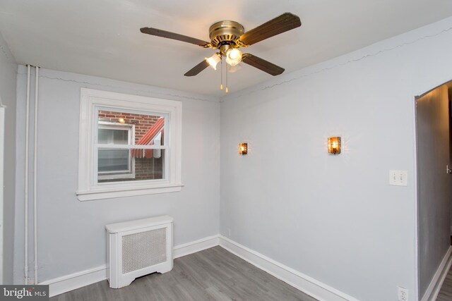 7152 N 20th St, Philadelphia, PA 19138 - spare room with radiator heating unit, wood finished floors, and a ceiling fan