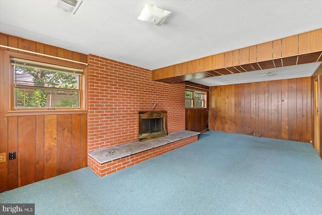 1605 N Amelia St, Sterling, VA 20164 - unfurnished living room with wooden walls, carpet flooring, plenty of natural light, and a brick fireplace