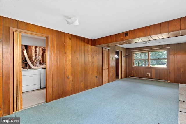1605 N Amelia St, Sterling, VA 20164 - empty room with a baseboard heating unit, wood walls, washer and clothes dryer, and carpet