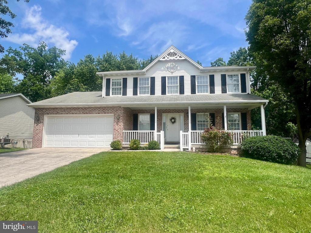 425 Lexington Way, Littlestown, PA 17340 - view of front of home featuring an attached garage, driveway, covered porch, a front yard, and brick siding