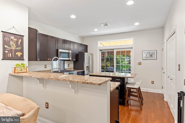 311 W 3rd Ave, Conshohocken, PA 19428 - kitchen with stainless steel appliances, a breakfast bar, a peninsula, light wood-style flooring, and recessed lighting