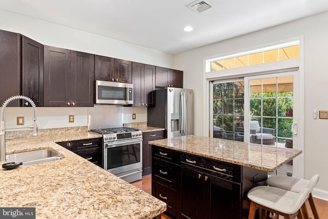 311 W 3rd Ave, Conshohocken, PA 19428 - kitchen with stainless steel appliances, a kitchen breakfast bar, wood finished floors, light stone countertops, and recessed lighting