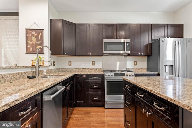 311 W 3rd Ave, Conshohocken, PA 19428 - kitchen featuring stainless steel appliances, light stone countertops, light wood-type flooring, and dark brown cabinets