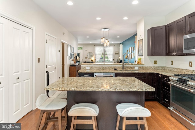 311 W 3rd Ave, Conshohocken, PA 19428 - kitchen with appliances with stainless steel finishes, light wood finished floors, open floor plan, a breakfast bar, and recessed lighting