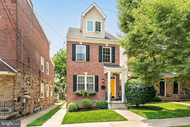 311 W 3rd Ave, Conshohocken, PA 19428 - view of front of home featuring brick siding, a front yard, and a shingled roof