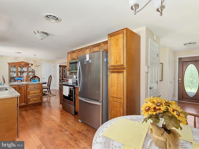 5409 Greenspring Valley Rd, Green Spring, WV 26722 - kitchen featuring stainless steel appliances, hardwood / wood-style floors, brown cabinetry, and light countertops