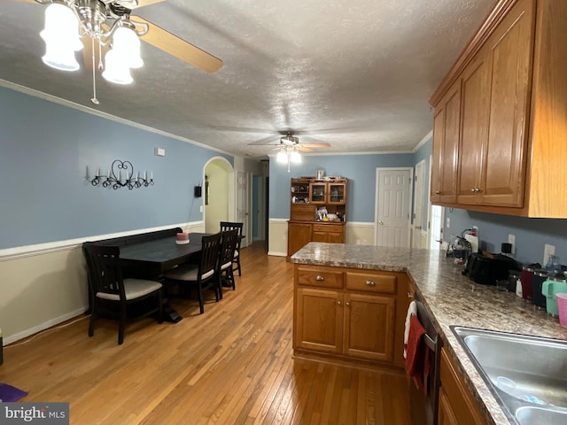 6197 Fishermans Way, Mechanicsville, VA 23116 - kitchen with ceiling fan, a peninsula, brown cabinetry, light wood finished floors, and arched walkways