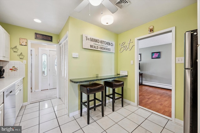 15 Paul Rd, Maple Shade, NJ 08052 - kitchen with baseboard heating, white cabinets, light tile patterned flooring, appliances with stainless steel finishes, and ceiling fan