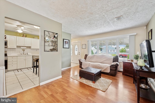 15 Paul Rd, Maple Shade, NJ 08052 - living area with light wood-style flooring, ceiling fan, a textured ceiling, and a baseboard radiator