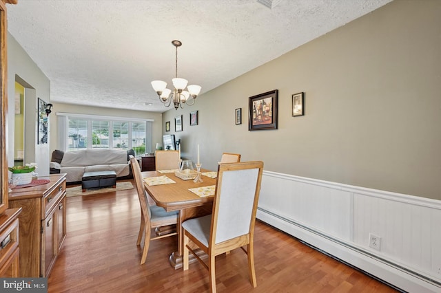 15 Paul Rd, Maple Shade, NJ 08052 - dining space with a baseboard heating unit, a textured ceiling, wood finished floors, a chandelier, and wainscoting