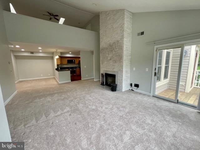 3801 Ridge Knoll Ct Unit 206A, Fairfax, VA 22033 - unfurnished living room with high vaulted ceiling, light carpet, a fireplace, and ceiling fan