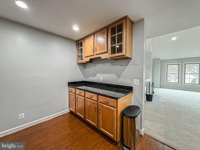 3801 Ridge Knoll Ct Unit 206A, Fairfax, VA 22033 - kitchen with brown cabinets, dark stone countertops, glass insert cabinets, recessed lighting, and dark wood-type flooring