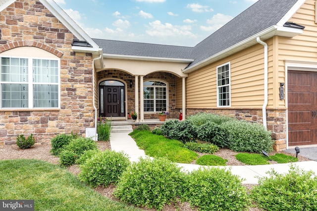 4136 Shanelle Ct Lot 10, Hampstead, MD 21074 - doorway to property featuring a shingled roof, covered porch, stone siding, and an attached garage