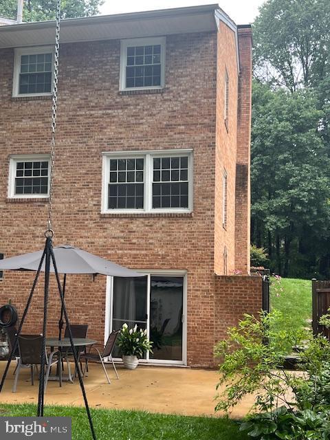 14861 Lambeth Sq, Centreville, VA 20120 - back of property featuring brick siding, a patio, and a chimney