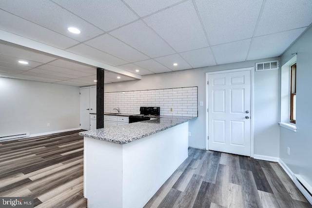 27 E Spring St, Frackville, PA 17931 - kitchen with black / electric stove, dark wood-style floors, a baseboard radiator, light stone countertops, and recessed lighting