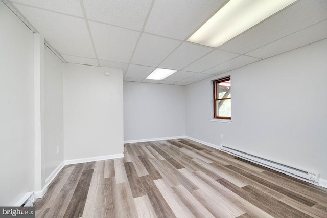 27 E Spring St, Frackville, PA 17931 - empty room featuring a baseboard heating unit, wood finished floors, and a drop ceiling