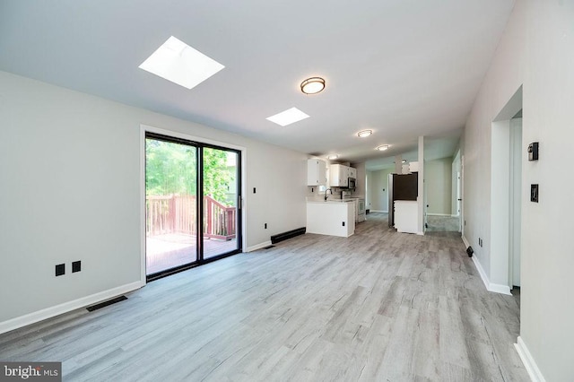 27 E Spring St, Frackville, PA 17931 - unfurnished living room featuring light wood-type flooring and a skylight