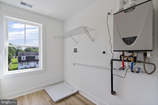 7108 River Drive Rd, Sparrows Point, MD 21219 - laundry area featuring tankless water heater, electric dryer hookup, hookup for a washing machine, and light wood-style floors