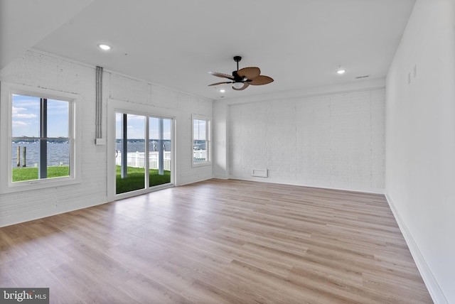 7108 River Drive Rd, Sparrows Point, MD 21219 - empty room featuring brick wall, plenty of natural light, a water view, wood finished floors, and recessed lighting