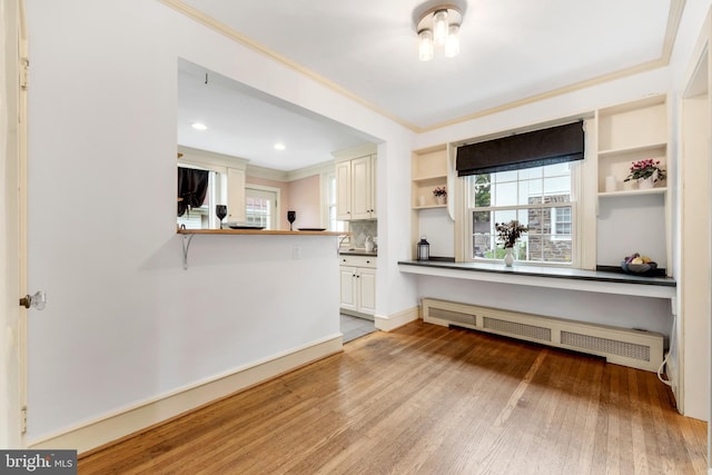 824 Lindale Ave, Drexel Hill, PA 19026 - kitchen with crown molding, radiator, open shelves, light wood finished floors, and dark countertops