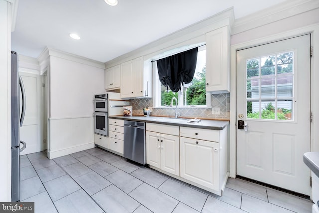 824 Lindale Ave, Drexel Hill, PA 19026 - kitchen featuring stainless steel appliances, plenty of natural light, tasteful backsplash, white cabinetry, and ornamental molding