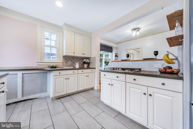 824 Lindale Ave, Drexel Hill, PA 19026 - kitchen with dark countertops, white cabinetry, and backsplash